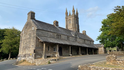 The old Church House in Widecombe in the Moor on Dartmoor under a blue sky.